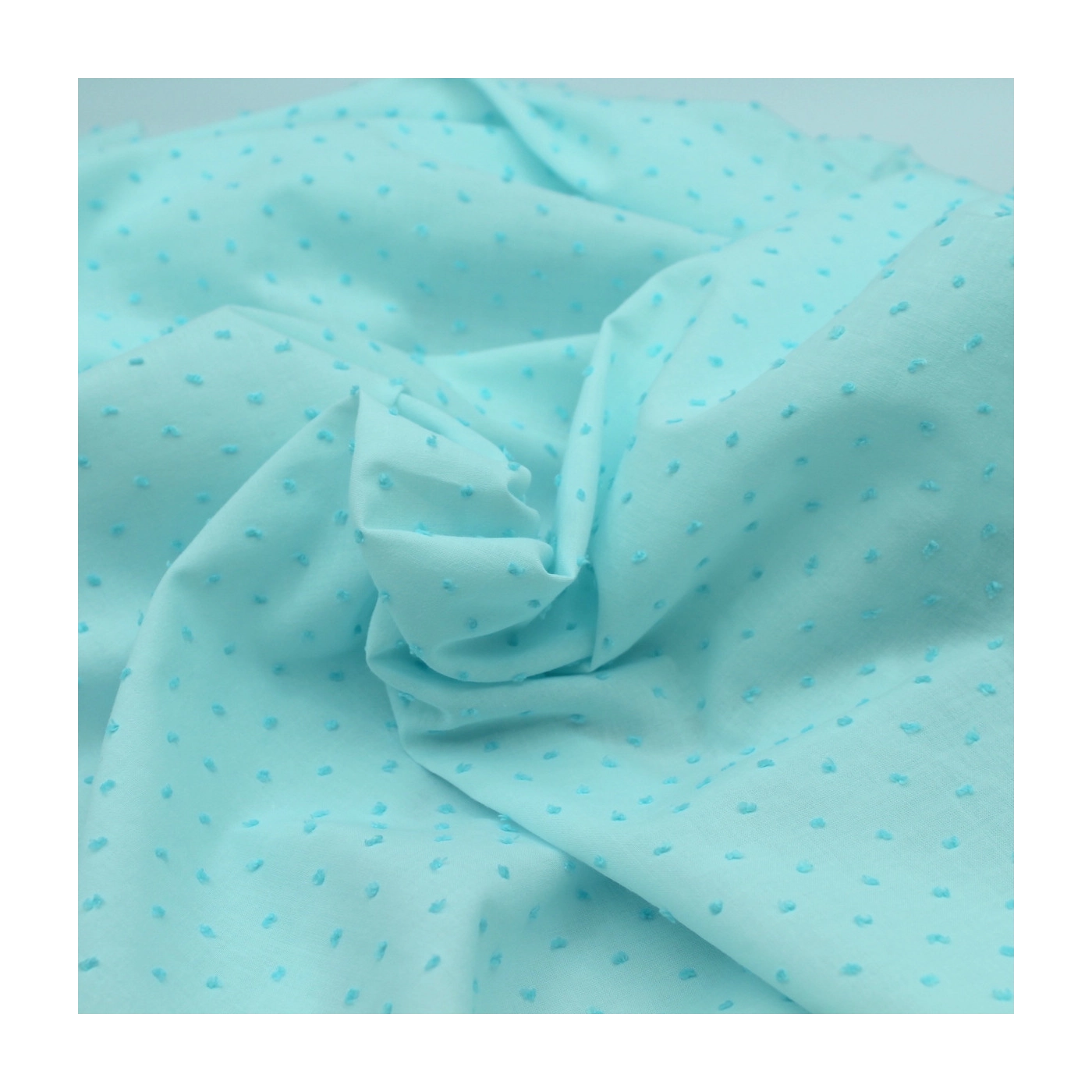 Tissu SORBET D’AMOUR pour les culottes Bootyful : voile de coton bleu pâle aux nuances lagon, ponctué de petits plumetis bleus plus soutenus en relief.
